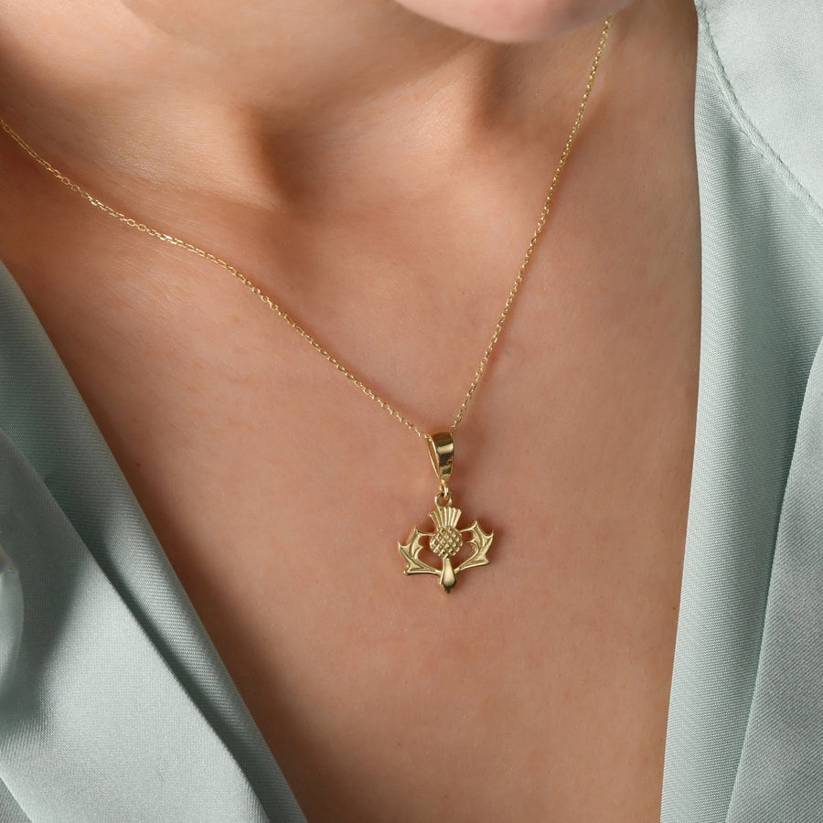 Woman wearing large 14ct gold thistle necklace statement piece
