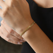 Woman wearing the 14ct gold curb chain bracelet, showcasing its elegant and minimalist style