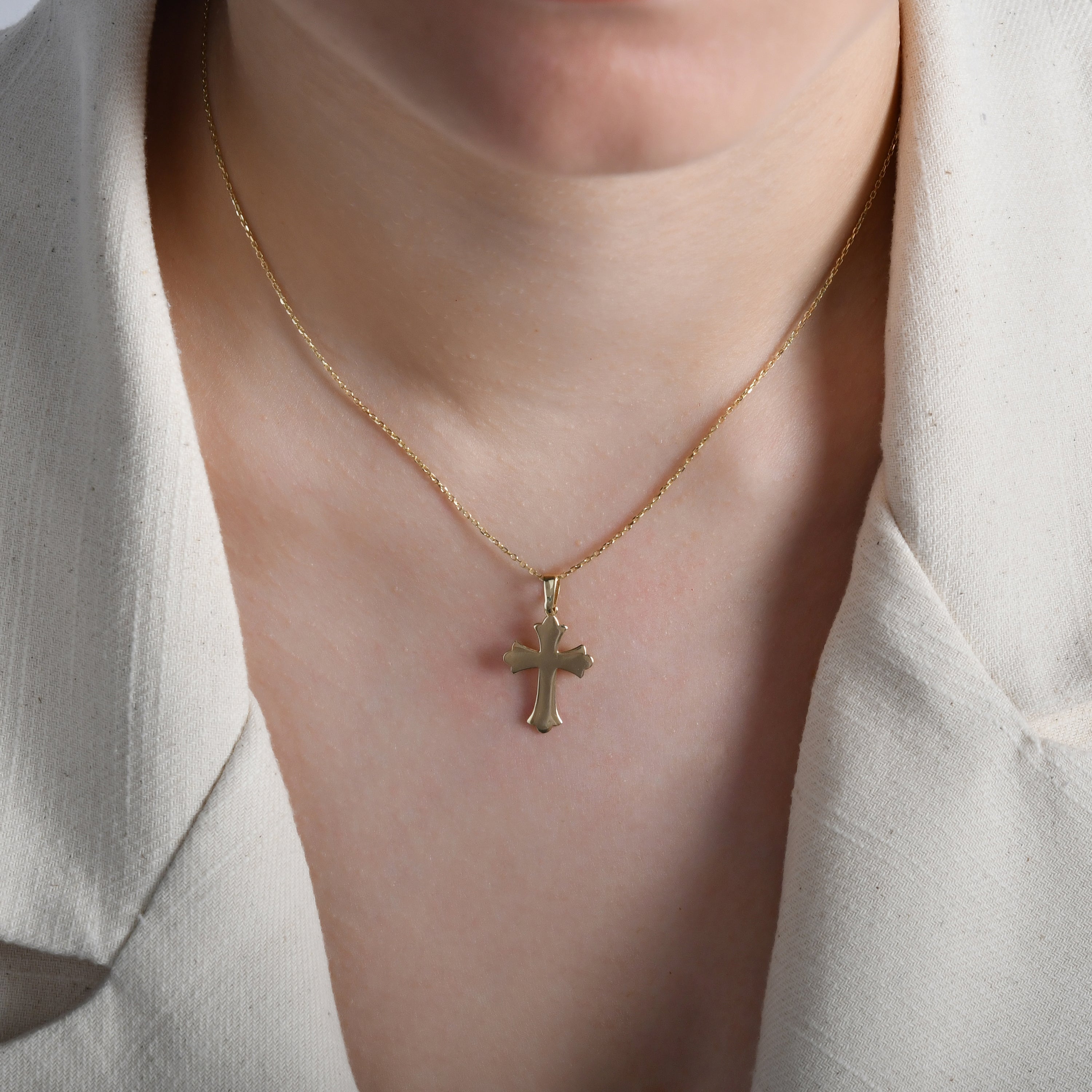 Model wearing the cross pendant to illustrate its elegant fit and versatile style.
