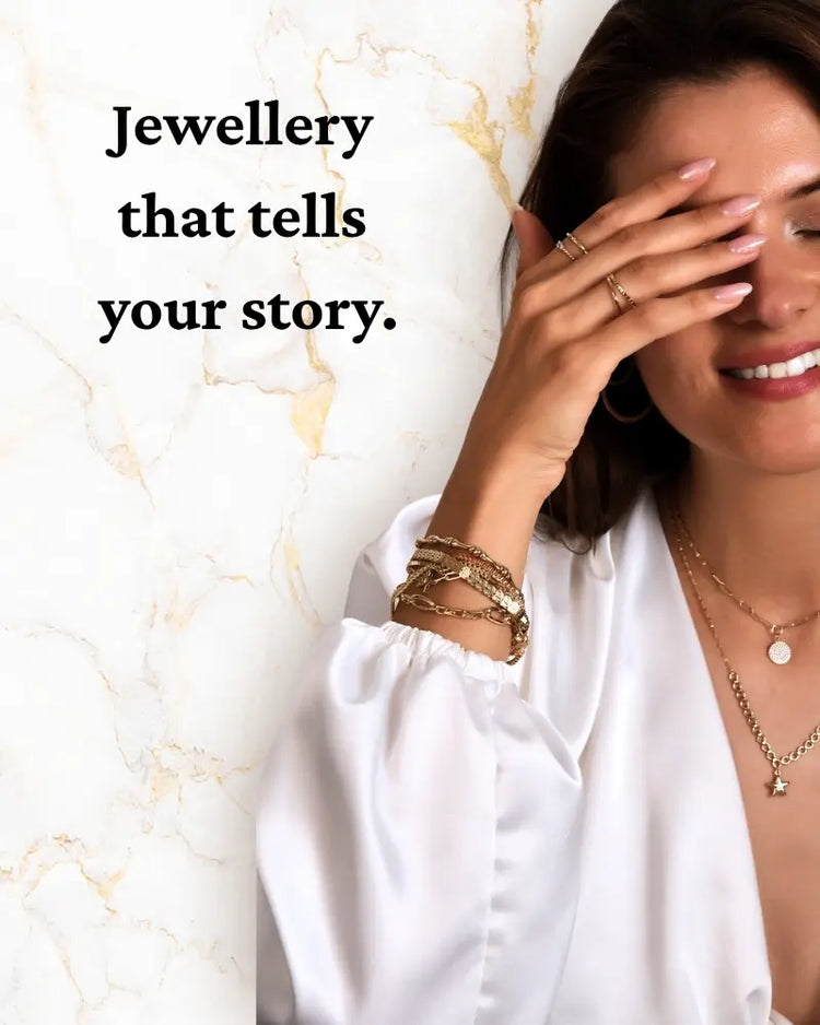 Woman wearing gold jewelry against a marble background