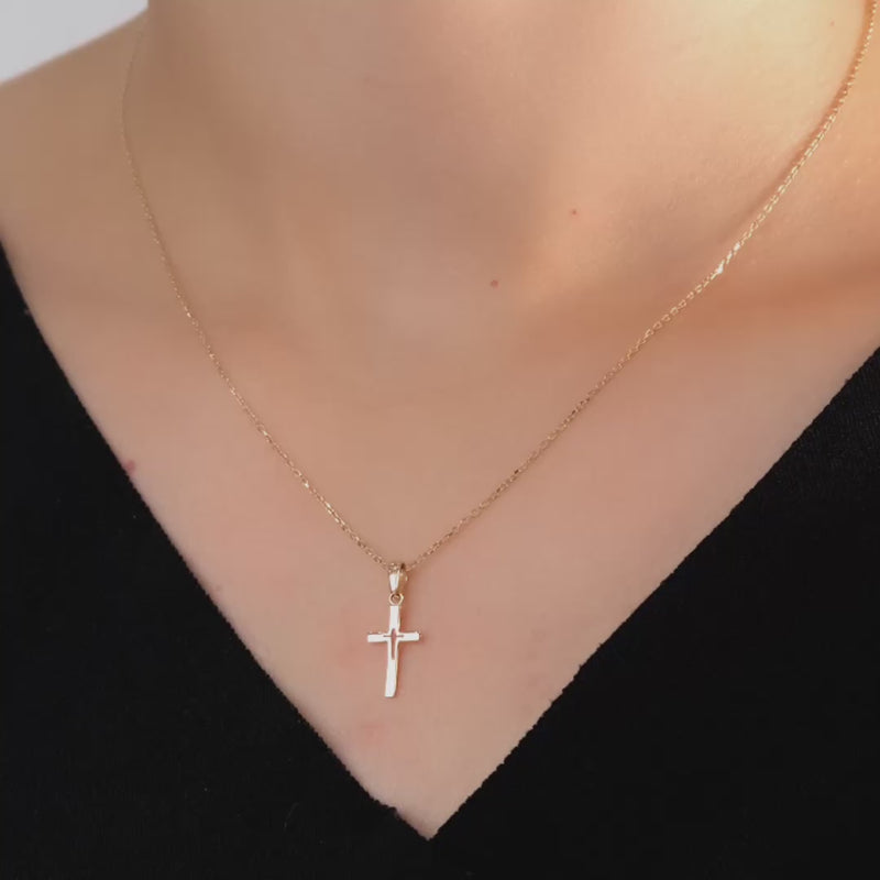 Video of model wearing the gold cross pendant to highlight its delicate and elegant fit.