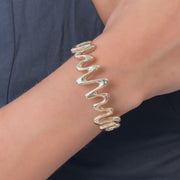 Woman wearing hallmarked 14ct solid gold zigzag bangle on wrist