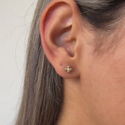 Close-up video of an ear wearing a four leaf clover gold earring