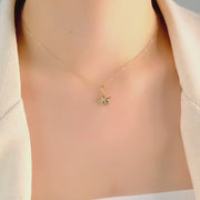 Close-up video of the 14ct Gold Starfish Pendant with a cubic zirconia centre, worn by a model.