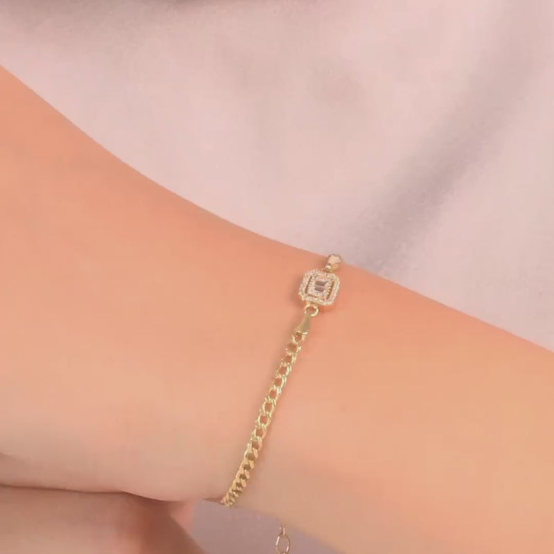 Women wearing video of delicate gold bracelet showcasing the cubic zirconia stone with an emerald cut and fine chain craftsmanship