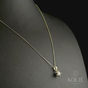 A detailed shot of the pendant with a chain, showcasing the sparkling cubic zirconia set in polished yellow gold.