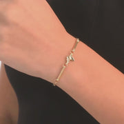 Video close-up of the gold bracelet worn on a woman's wrist, showing the sparkling cubic zirconia stones in the elegant design