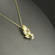 Yellow Gold Cherub pendant displayed on a black background, with the chain