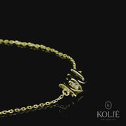 Sophisticated Kolié 9ct gold 'Love' bracelet with "I love you" sign and a solitary shimmering stone, presented on a pure white backdrop, a timeless token of affection available at www.kolie.co.uk."