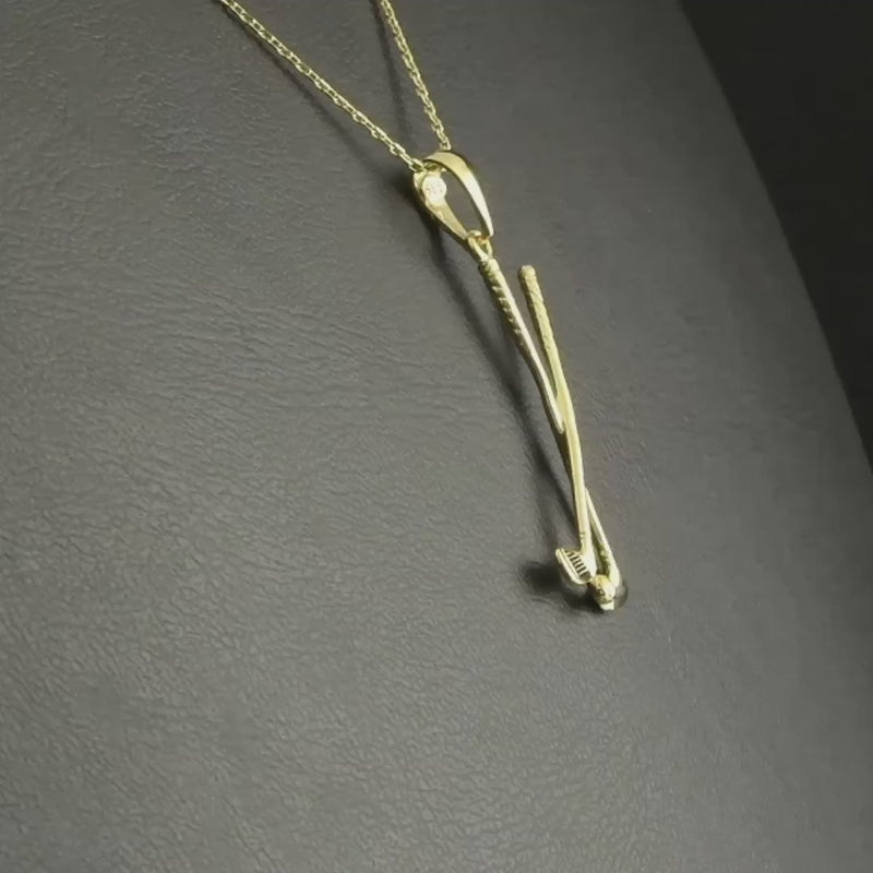 Close-up video of 14ct gold golf pendant, showing crossed golf clubs and ball.