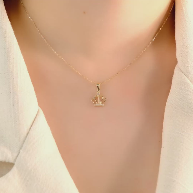 14ct solid gold crown pendant on a model, showing its elegant fit and design.