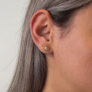 Gold stud earrings on a model