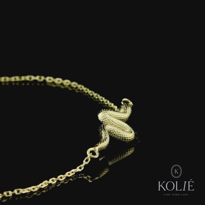 Sleek 9ct gold bracelet featuring a serpentine design element in the center, symbolizing transformation and vitality, displayed on a dainty gold chain against a pure white background, from Kolié's unique jewelry series.