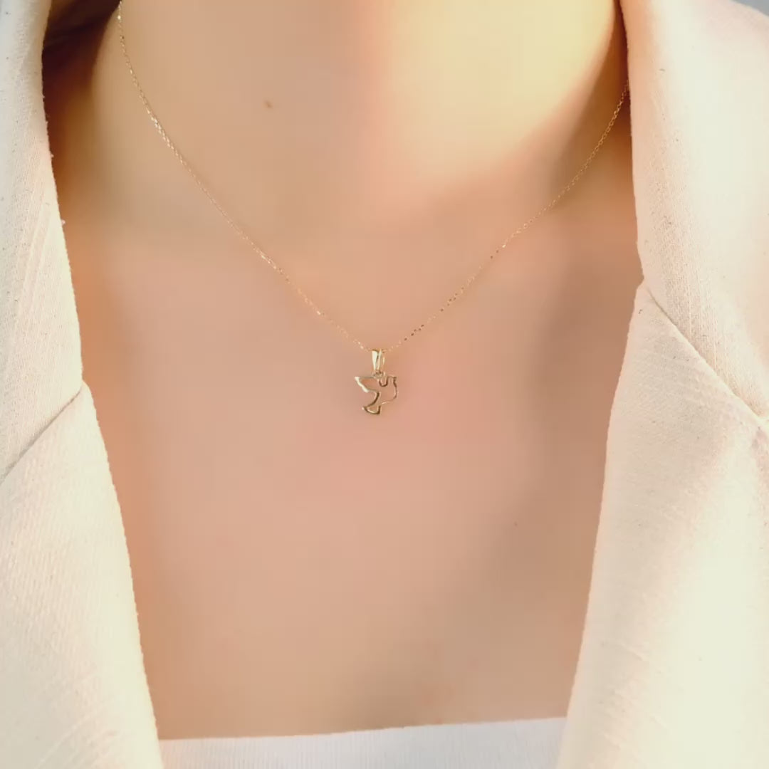 Model wearing the gold dove pendant to highlight its fit and size.