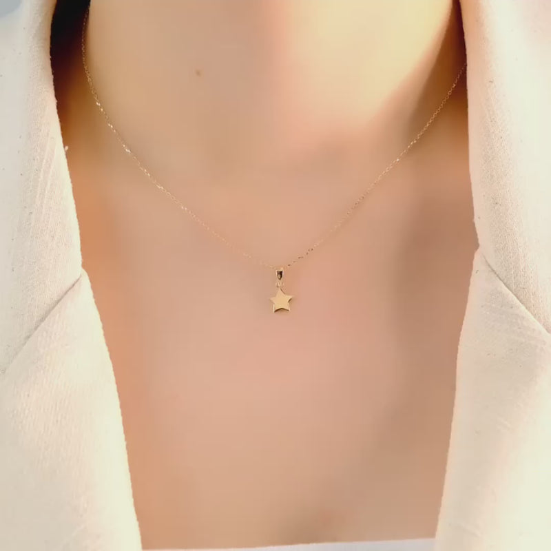 Video of the minimalist gold star pendant displayed on a model to highlight its size and fit 
