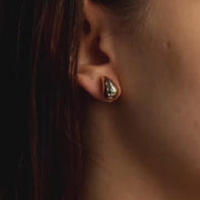 Detailed view of the polished surface of large 14ct gold teardrop earrings, reflecting light and showcasing their standout size and design