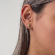 Gold flower shaped stud earring on a model