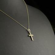 Close-up of a 9ct yellow gold cross pendant adorned with pave-set cubic zirconia stones, ideal religious jewellery gift
