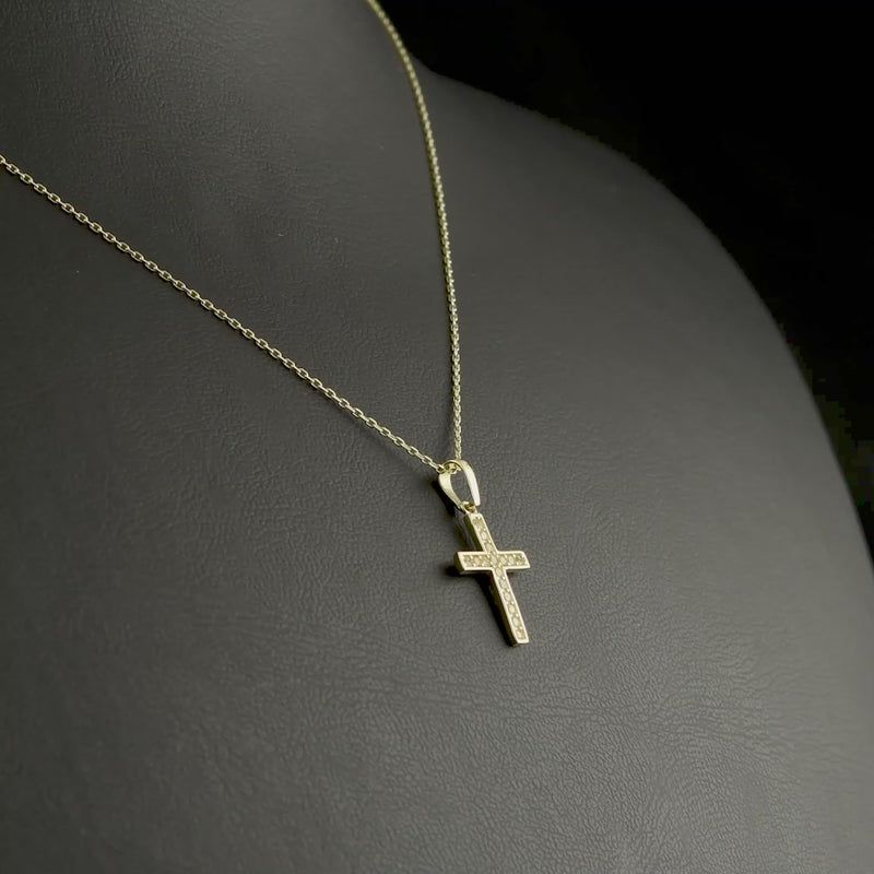 Close-up of a 9ct yellow gold cross pendant adorned with pave-set cubic zirconia stones, ideal religious jewellery gift